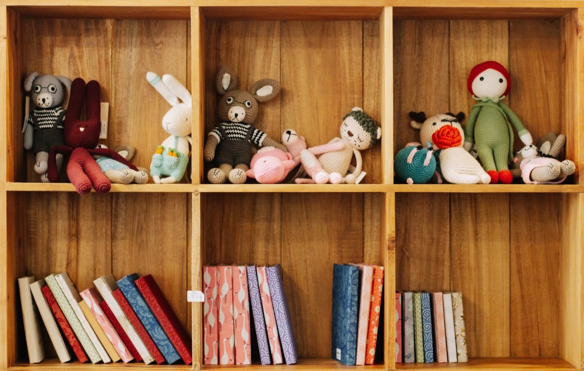 assorted animal plush toys on brown wooden shelf