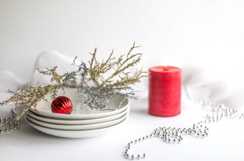 red pillar candle on white ceramic saucer