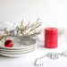 red pillar candle on white ceramic saucer